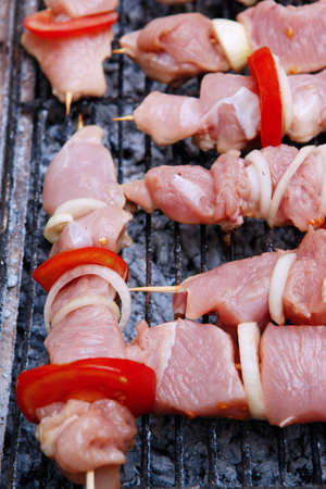 fresh raw turkey pork red meat fillet shish kebab on wooden skewers over vintage kind brazier full with ready charcoalの写真素材