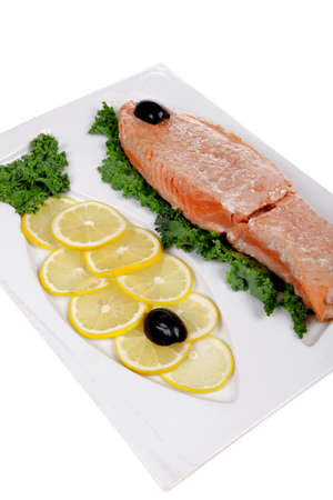 healthy food - fresh roast red fish salmon with kale lemon and black olives on plate isolated on white background space for textの写真素材