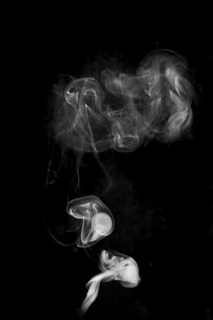white textured smoke powder fluffy puffs explosion dust isolated on dark background as brushの写真素材