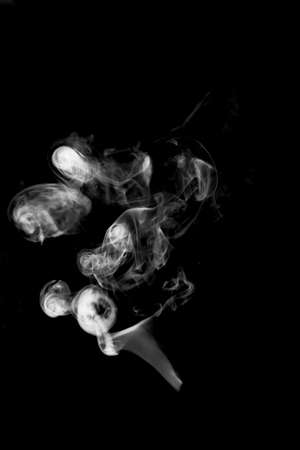 white textured smoke powder fluffy puffs explosion dust isolated on dark background as brushの写真素材