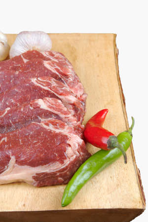 sirloin sinta fillet sliced on wooden plate with garlic and green red hot pepper isolated over white background with white empty menu plate for text nearの写真素材