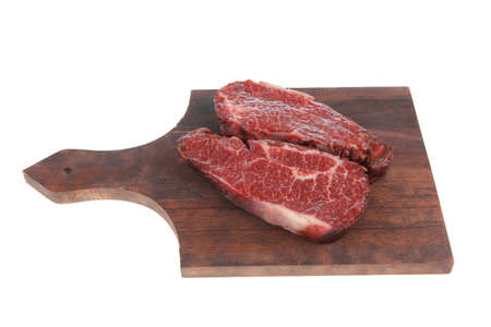 two fresh raw marble beef meat sirloin porterhouse steak on dark wood cut board isolated on white backgroundの写真素材