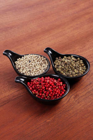 fresh dry peppercorn in small black bowl on wooden table ready to cookの写真素材