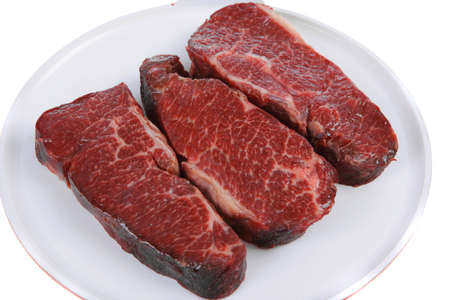 three fresh raw marble beef meat sirloin porterhouse steak on big ceramic cooking pan isolated on white backgroundの写真素材