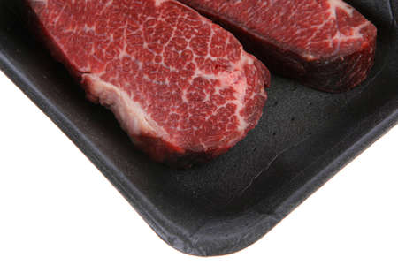 two fresh raw marble beef meat sirloin porterhouse steak on black market plastic tray isolated on white backgroundの写真素材