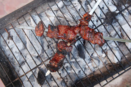 fresh beef meat kebab on barbecue grid grill cooked over burned churcoalの写真素材