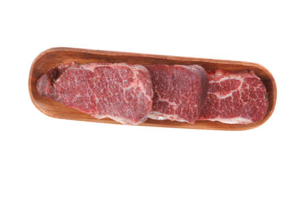 three fresh raw marble beef meat sirloin porterhouse steak on long wooden tray isolated on white backgroundの写真素材