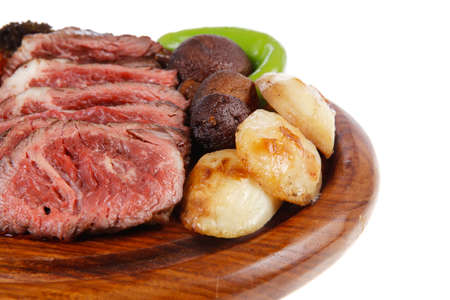 fresh grilled bbq beef meat rib eye steak on wooden plate with baked tomatoes mushroom, potatoes, hot chili pepper isolated on white backgrodun empty space for textの写真素材