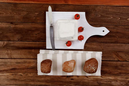 dairy healthy food fresh white greek goat sheep feta cheese on wood cutting plate with cherry...