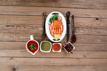 breakfast delicious portion of fresh roast salmon fillet with green chili sauce tomato soup dry spices over wooden table with black forged handmade cutlery - healthy food, diet cooking conceptの写真素材