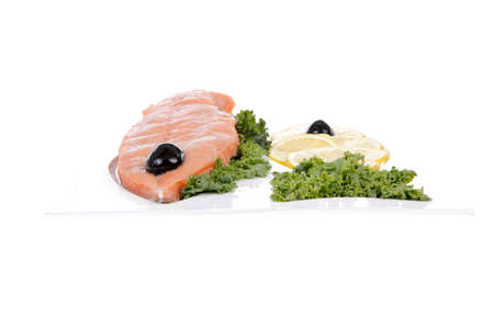 healthy food - fresh raw red fish with kale lemon and black olives on plate isolated on white background space for textの写真素材