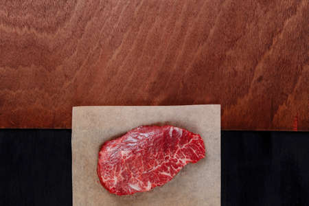 fresh raw beef rib eye steak on black walnut wooden tableの写真素材