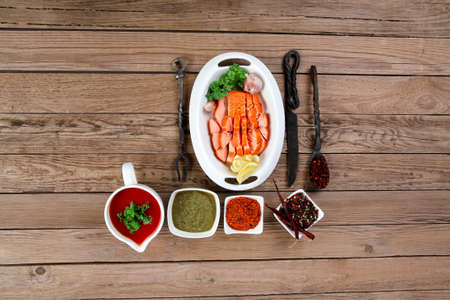breakfast delicious portion of fresh roast salmon fillet with green chili sauce tomato soup dry spices over wooden table with black forged handmade cutlery - healthy food, diet cooking conceptの写真素材