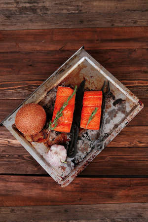 delicious portion of raw fresh salmon fillet with aromatic herbs and spices on vintage tray over wooden table - healthy food, diet cooking concept with background spaceの写真素材
