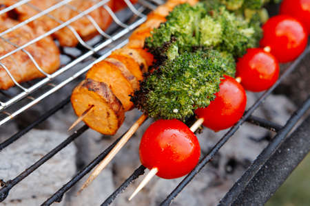 fresh raw vegetable kebab on bbq grid cooked over hot burned charcoalの写真素材