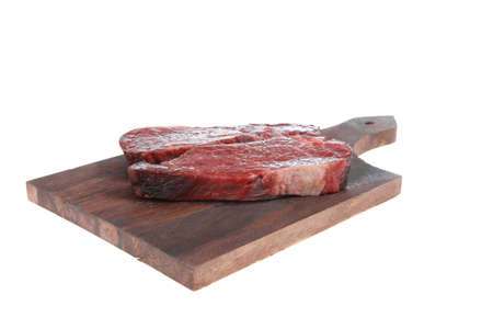 two fresh raw marble beef meat sirloin porterhouse steak on dark wood cut board isolated on white backgroundの写真素材