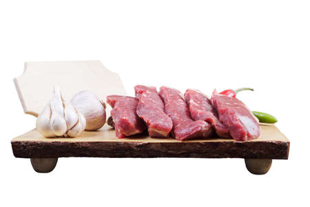 sirloin sinta fillet sliced on wooden plate with garlic and green red hot pepper isolated over white background with white empty menu plate for text nearの写真素材