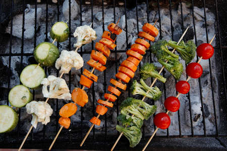 fresh raw vegetable kebab on bbq grid cooked over hot burned charcoalの写真素材