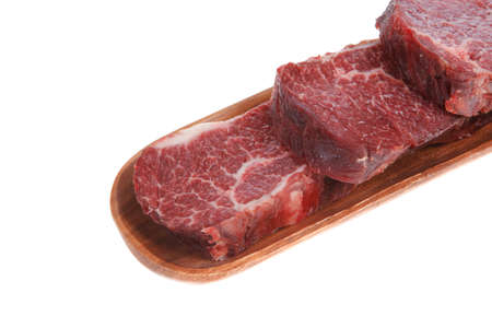 three fresh raw marble beef meat sirloin porterhouse steak on long wooden tray isolated on white backgroundの写真素材