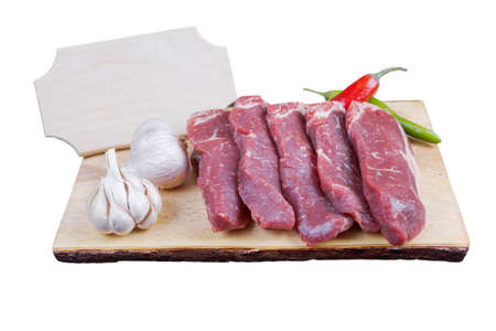 sirloin sinta fillet sliced on wooden plate with garlic and green red hot pepper isolated over white background with white empty menu plate for text nearの写真素材