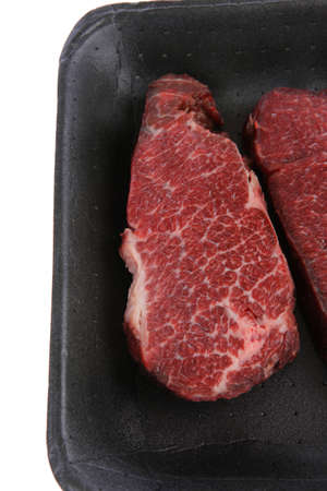 two fresh raw marble beef meat sirloin porterhouse steak on black market plastic tray isolated on white backgroundの写真素材