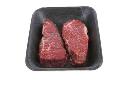 two fresh raw marble beef meat sirloin porterhouse steak on black market plastic tray isolated on white backgroundの写真素材