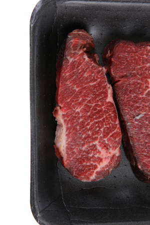 two fresh raw marble beef meat sirloin porterhouse steak on black market plastic tray isolated on white backgroundの写真素材