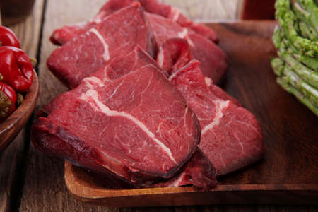 fresh beef meat asparagus greenery spices cutlery wooden table pepper crushed hot chili vegetables...