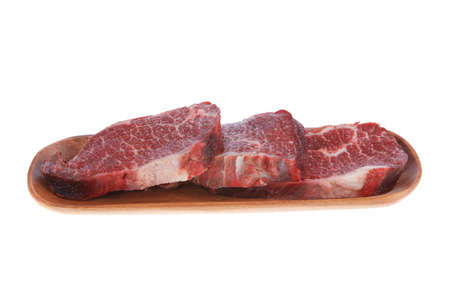 three fresh raw marble beef meat sirloin porterhouse steak on long wooden tray isolated on white backgroundの写真素材