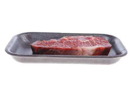 fresh raw marble beef meat steak on black plastic market tray isolated on white backgroundの写真素材