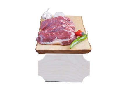 sirloin sinta fillet sliced on wooden plate with garlic and green red hot pepper isolated over white background with white empty menu plate for text nearの写真素材
