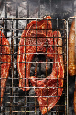 grilled roast meat lamb ribs on barbecue grid over charcoalの写真素材