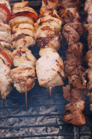 fresh raw beef fillet steak red meat and white chicken brisket on skewers barbecue brazier grid full burned charcoalの写真素材