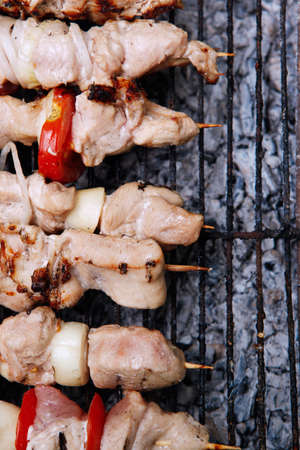 fresh turkey pink brisket shish kebab on wooden skewers with tomatoes over barbecue brazier full burned charcoalの写真素材