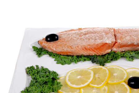 healthy food - fresh roast red fish salmon with kale lemon and black olives on plate isolated on white background space for textの写真素材