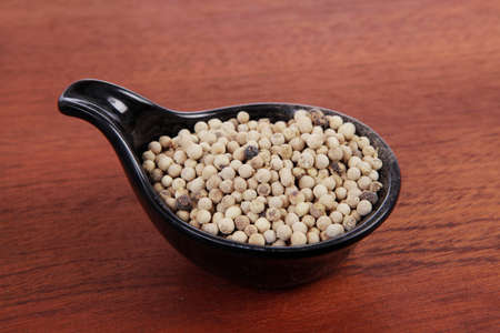 fresh dry peppercorn in small black bowl on wooden table ready to cookの写真素材