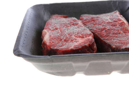 two fresh raw marble beef meat sirloin porterhouse steak on black market plastic tray isolated on white backgroundの写真素材