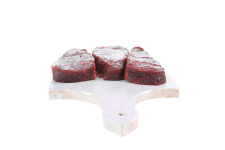 three fresh raw marble beef meat sirloin porterhouse steak on light wood cut board isolated on white backgroundの写真素材