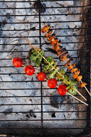 fresh raw vegetable kebab on bbq grid cooked over hot burned charcoalの写真素材
