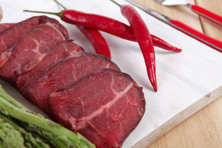 fresh beef meat slices asparagus spices cutlery wooden table pepper hot chili vegetables served...