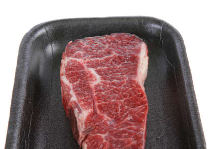 fresh raw marble beef meat steak on black plastic market tray isolated on white backgroundの写真素材