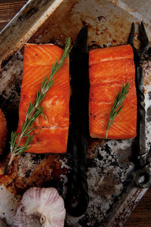 delicious portion of raw fresh salmon fillet with aromatic herbs and spices on vintage tray over wooden table - healthy food, diet cooking conceptの写真素材