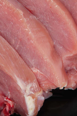 fresh raw turkey pieces on black pan isolated over white backgroundの写真素材