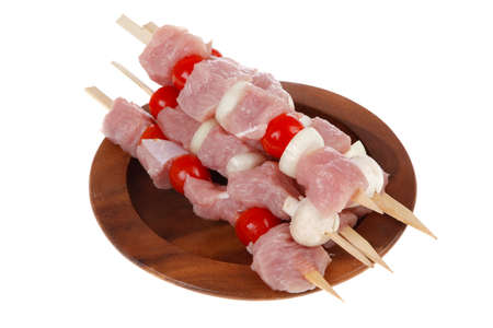 fresh raw meat fillet shish kebab turkey pork pink on skewers tomatoes mushrooms on wooden dish isolated over white backgroundの写真素材