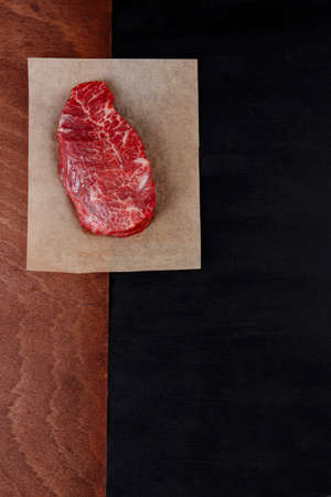 fresh raw beef rib eye steak on black walnut wooden tableの写真素材