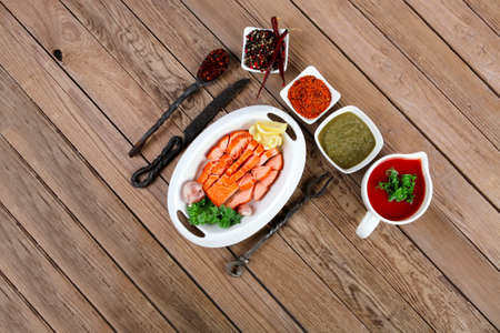 breakfast delicious portion of fresh roast salmon fillet with green chili sauce tomato soup dry spices over wooden table with black forged handmade cutlery - healthy food, diet cooking conceptの写真素材