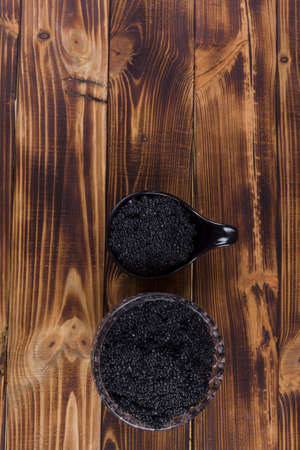 fresh raw black sturgeon hausen caviar in white crystal bowl on wooden backgroundの写真素材