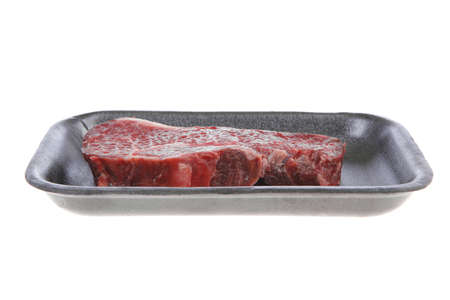 fresh raw marble beef meat steak on black plastic market tray isolated on white backgroundの写真素材