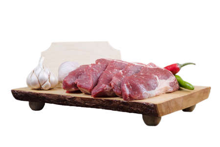 sirloin sinta fillet sliced on wooden plate with garlic and green red hot pepper isolated over white background with white empty menu plate for text nearの写真素材
