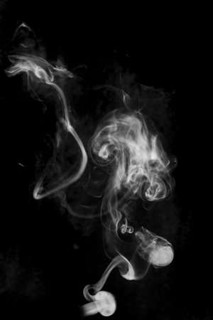 white textured smoke powder fluffy puffs explosion dust isolated on dark background as brushの写真素材